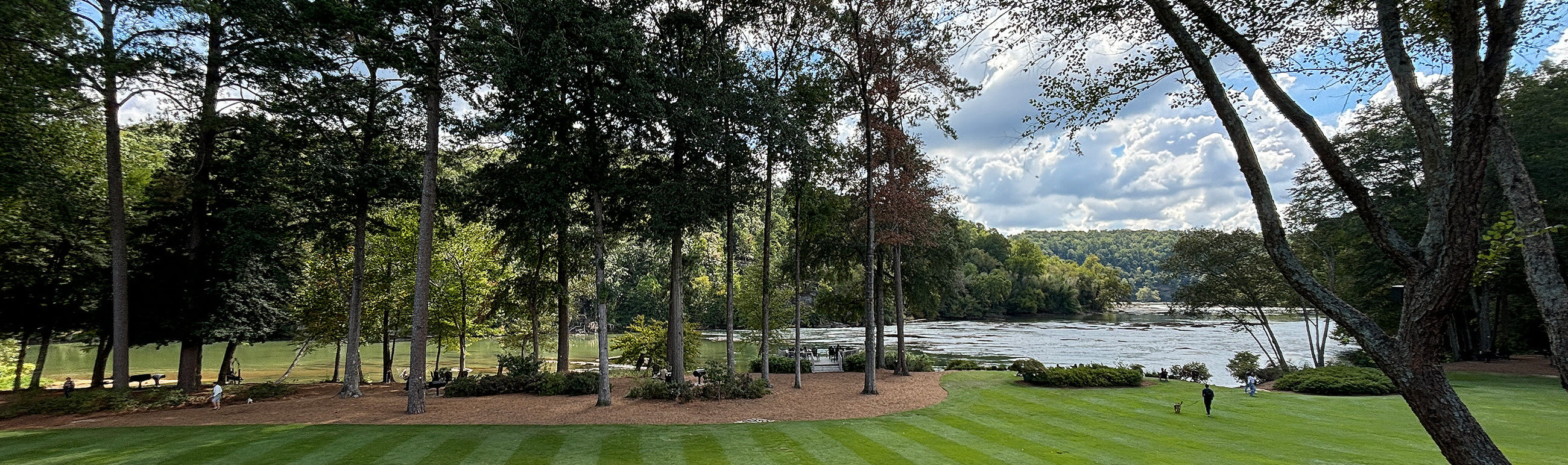 a lakefront area with picnic tables and walk paths