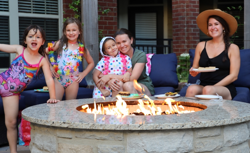 Residents by fire pit enjoying community amenities