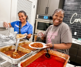 two women preparing a plate of food