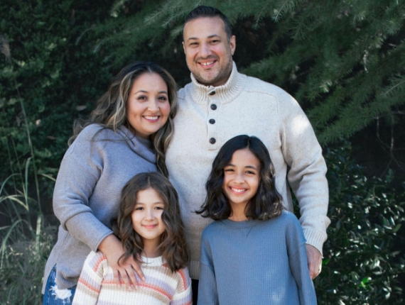 a family of four takes a picture outdoors