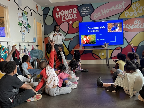 children with raised hands in a classroom